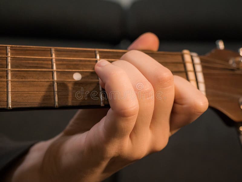 Practice Playing the Acoustic Guitar. Hands Playing Guitar and Picking Chords Stock Photo
