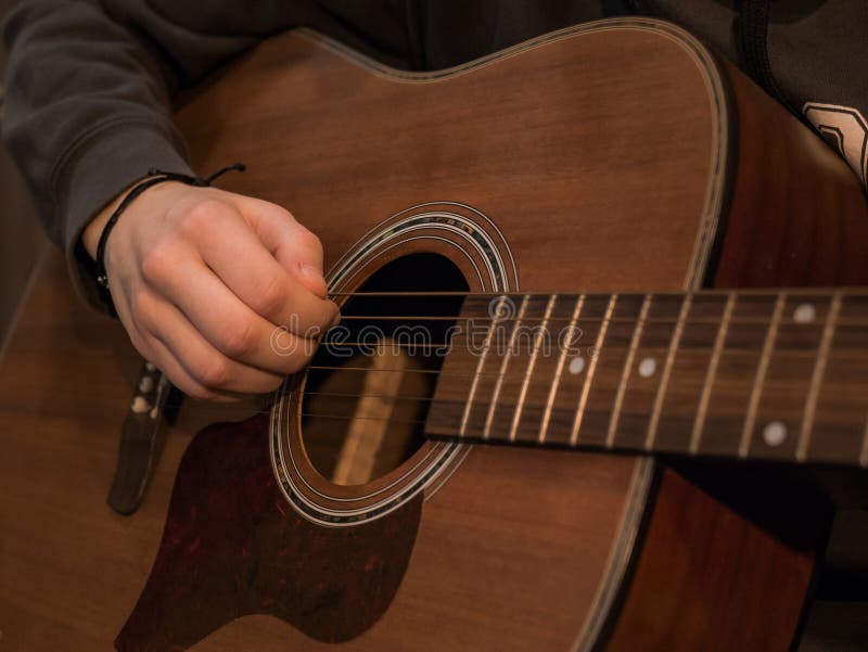 Practice Playing the Acoustic Guitar. Hands Playing Guitar and Picking