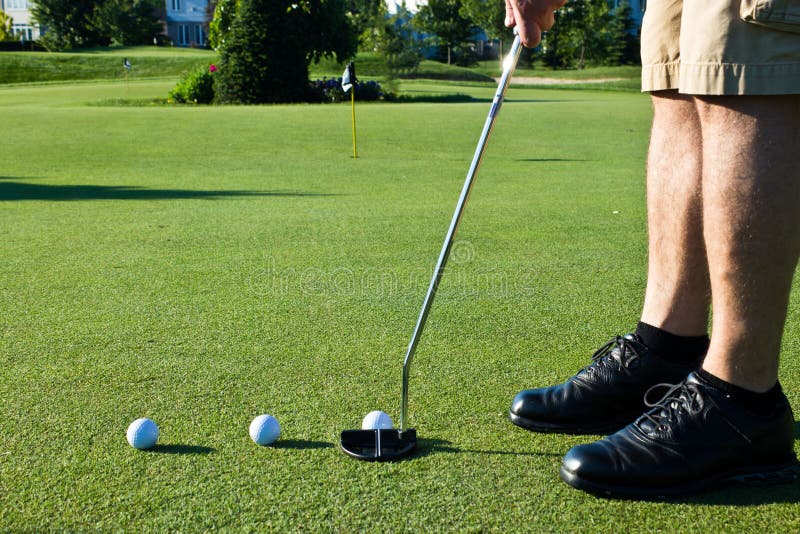 Golfer Practicing Putting with Several Golf Balls Stock Photo Image