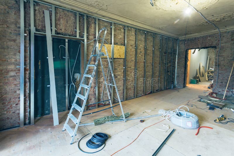 Pracujący proces instalować metal ramy dla plasterboard drywall dla robić gips ścianom z drabiną i narzędziom w mieszkaniu obrazy stock Pracujący proces instalować metal ramy dla plasterboard drywall dla robić gips ścianom z drabiną i narzędziom w mieszkaniu obrazy stock