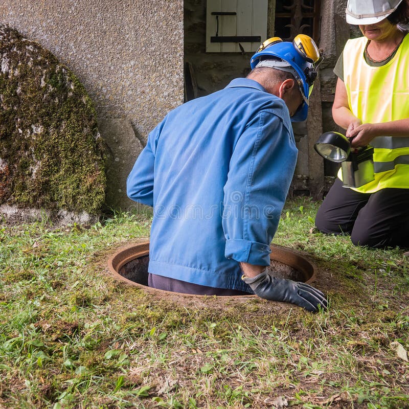 Pracy w manhole drużyną mężczyzna i kobieta zdjęcie royalty free Pracy w manhole drużyną mężczyzna i kobieta zdjęcie royalty free
