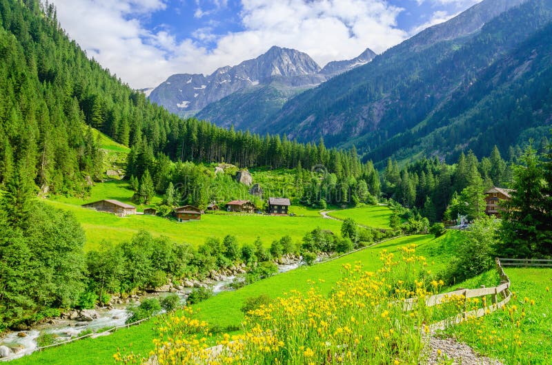 Prados verdes, casas de campo alpinas nos cumes, Áustria