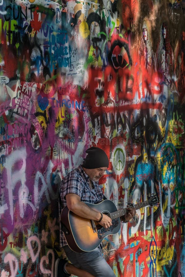 Prag, Tschechische Republik - 10. September 2019: Straße Busker, der an Beatles-Lieder vor John Lennon Wall durchführt lizenzfreies stockbild Prag, Tschechische Republik - 10. September 2019: Straße Busker, der an Beatles-Lieder vor John Lennon Wall durchführt lizenzfreies stockbild