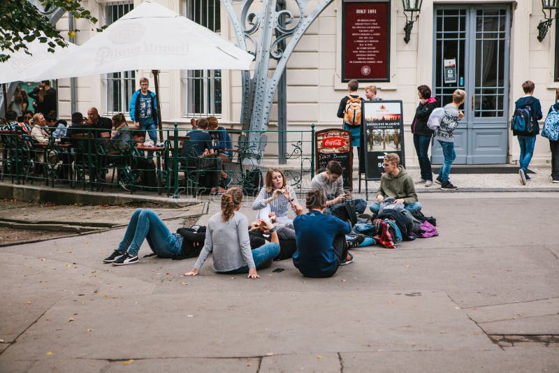 Praga, el 25 de septiembre de 2017: Un grupo de amigos jovenes de estudiantes miente y se sienta en la tierra y comunica con cada imagen de archivo libre de regalías Praga, el 25 de septiembre de 2017: Un grupo de amigos jovenes de estudiantes miente y se sienta en la tierra y comunica con cada imagen de archivo libre de regalías