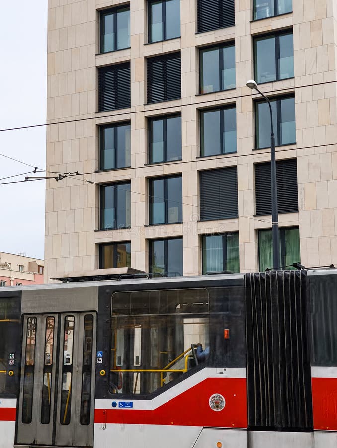 Praga Repubblica ceca 24 marzo 2025 : Tram rosso bianco che passa per l'edificio moderno nel distretto di Zizkov Prague 3 czechia fotografia stock