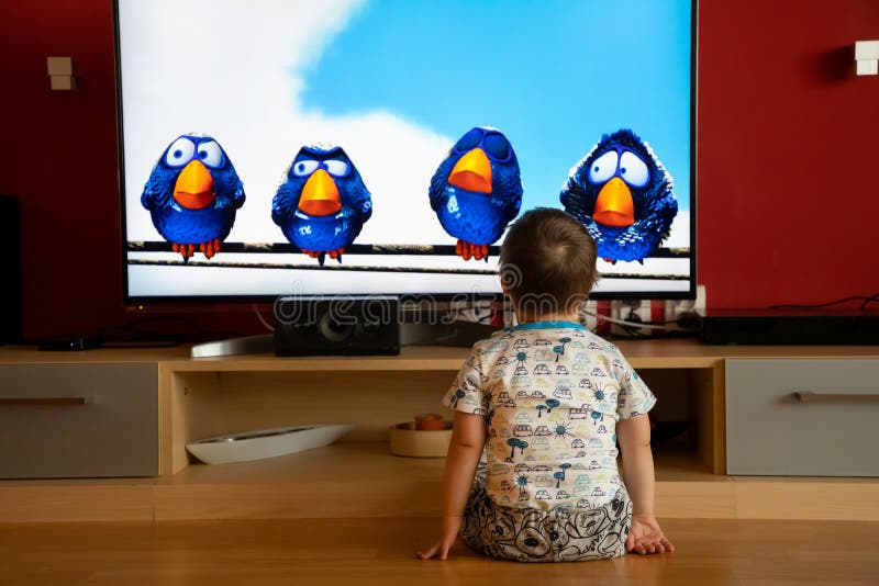 Praga, República Checa -18 03 2019: Menino pequeno com desenhos animados de observação de Síndrome de Down imagem de stock Praga, República Checa -18 03 2019: Menino pequeno com desenhos animados de observação de Síndrome de Down imagem de stock