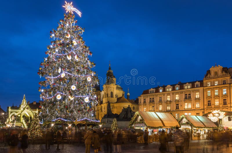 Prague Christmas market on the night in Old Town Square. Tyn Church, Bohemia. Blurred people on the move. Prague, Czech Republic.