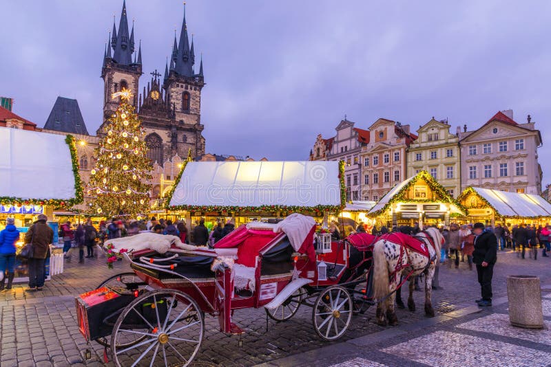 Prague Christmas market on the night in Old Town Square. Tyn Church, Bohemia. Blurred people on the move. Prague, Czech Republic.