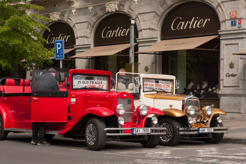 PRAGUE, CZECH REPUBLIC - APRIL 21, 2017: Two vintage Ford cars parked in front of a Cartier shop in the Parizska street royalty free stock image PRAGUE, CZECH REPUBLIC - APRIL 21, 2017: Two vintage Ford cars parked in front of a Cartier shop in the Parizska street royalty free stock image