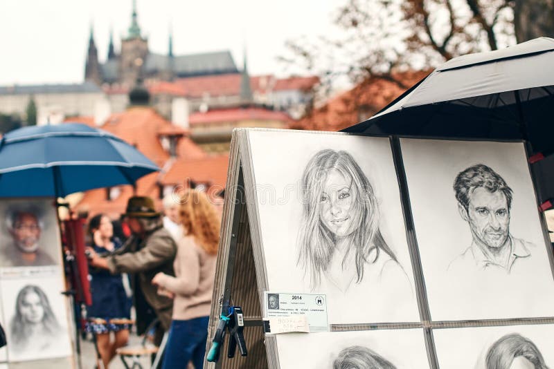 Prague, Czech Republic - September 27, 2014: Street portrait painter and examples of his art drawn with pencil. stock photo Prague, Czech Republic - September 27, 2014: Street portrait painter and examples of his art drawn with pencil. stock photo