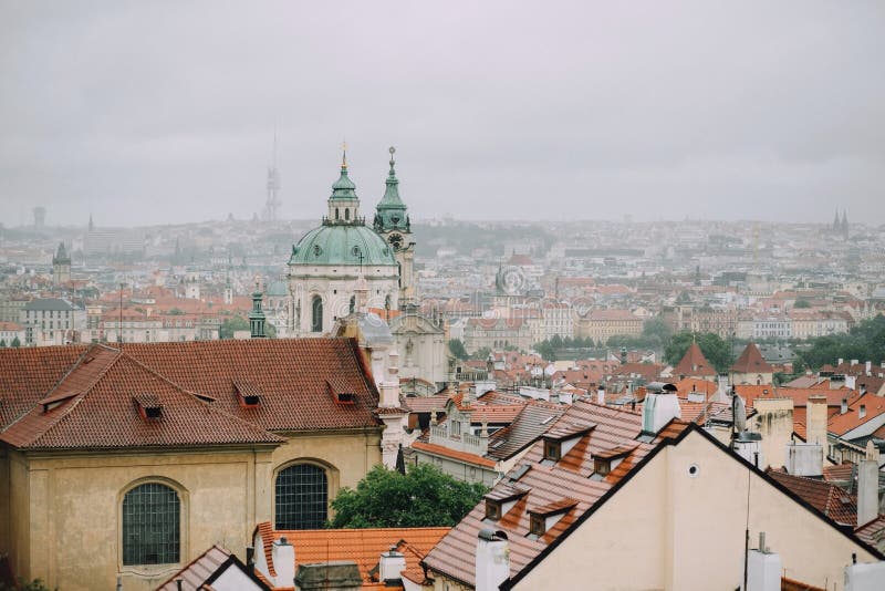 Prague, République Tchèque - mai 2014 Vue de la ville dans le brouillard et les toits et l'église rouges de Saint-Nicolas image stock Prague, République Tchèque - mai 2014 Vue de la ville dans le brouillard et les toits et l'église rouges de Saint-Nicolas image stock