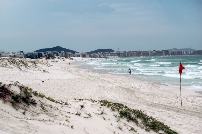 Praia das dunas με μια όμορφη θαλάσσια λευκή αμμώδη θόλο και την πόλη στο παρασκήνιο. στοκ φωτογραφία με δικαίωμα ελεύθερης χρήσης
