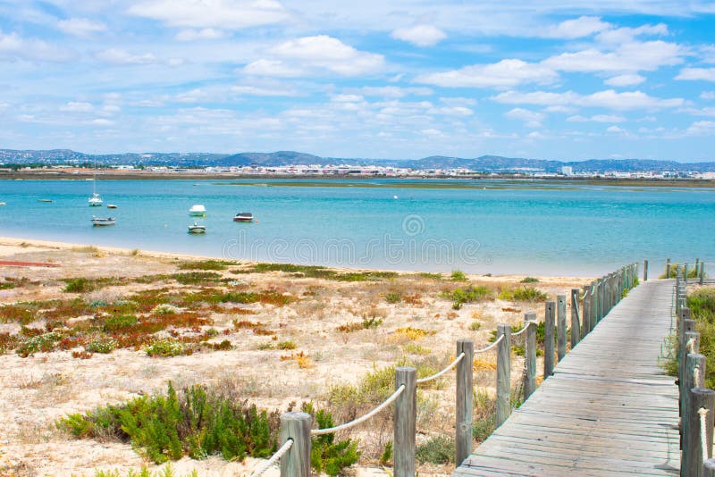 Praia De Faro, Algarve, Portugal. Aerial view on coast of ocean and beach. Boats on water, drone view