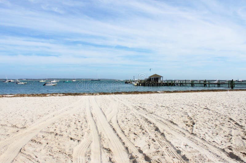 Praia e pouco porto perto de Kennedy Compound no porto de Hyannis em Cape Cod com barcos na água e em um surfista do vento no dis fotos de stock Praia e pouco porto perto de Kennedy Compound no porto de Hyannis em Cape Cod com barcos na água e em um surfista do vento no dis fotos de stock