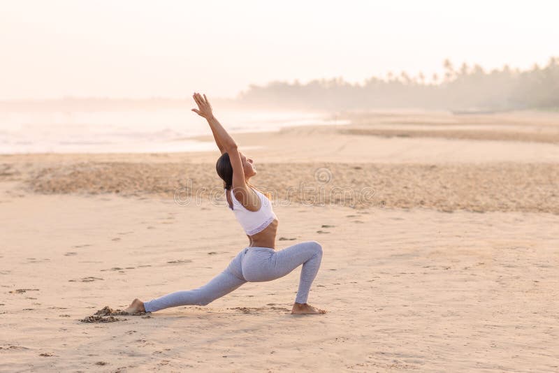 Praktiserande yoga f?r Caucasian kvinna p? kusten av v?ndkretshavet arkivfoton Praktiserande yoga f?r Caucasian kvinna p? kusten av v?ndkretshavet arkivfoton