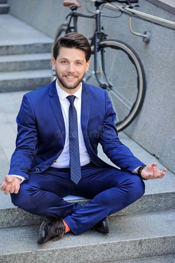 Praktiserande yoga för ung affärsman på trappa royaltyfri bild Praktiserande yoga för ung affärsman på trappa royaltyfri bild