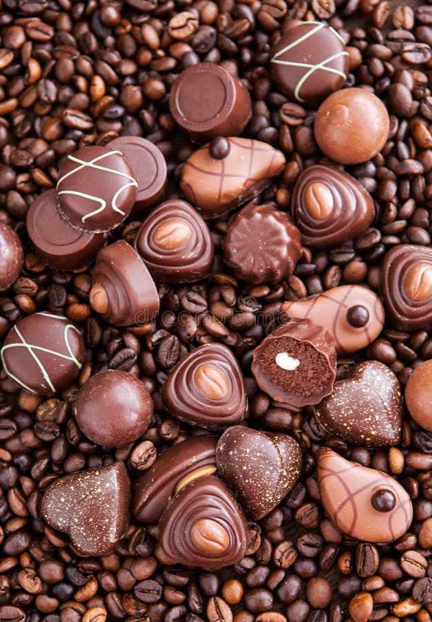 Pralines assorties de chocolat sur le fond de grains de café images libres de droits Pralines assorties de chocolat sur le fond de grains de café images libres de droits