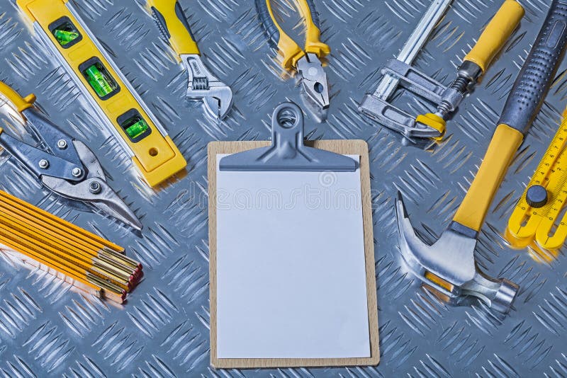 Prancheta brilhante do conceito da construção da versão com papel vazio branco e muitas ferramentas em folha ondulada imagem de stock Prancheta brilhante do conceito da construção da versão com papel vazio branco e muitas ferramentas em folha ondulada imagem de stock