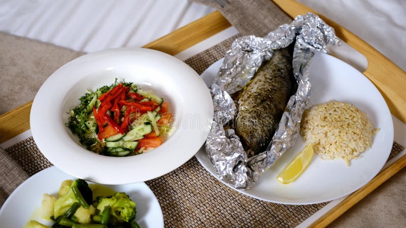 Pranzo con insalata di pesce e verdure bollite su vassoio di legno in camera d'albergo. video d archivio