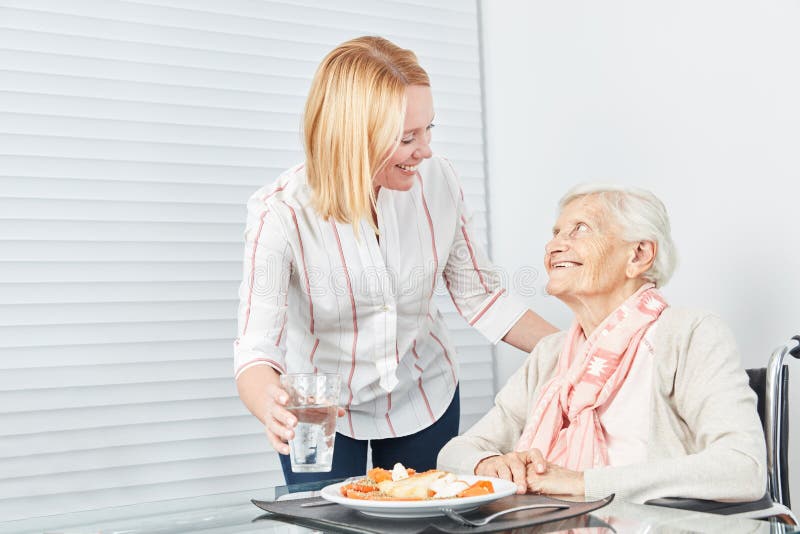 Pranzo del servizio della giovane donna all'anziano fotografia stock libera da diritti Pranzo del servizio della giovane donna all'anziano fotografia stock libera da diritti
