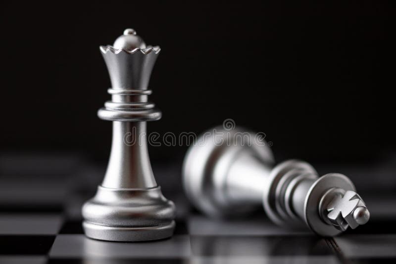 A peça de xadrez da rainha dourada em pé com o cavaleiro de prata
