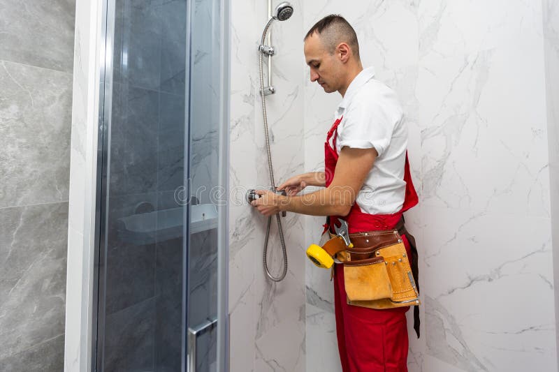 Pratique handyman travaillant dans cabine de douche à l'intérieur photographie stock libre de droits