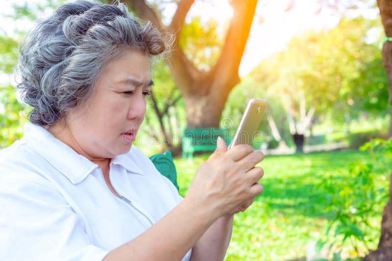 Praxis der Großmutter oder der älteren Frau, die Social Media durch die Anwendung von Smartphone spielt Großmutter durcheinanderk lizenzfreie stockfotos Praxis der Großmutter oder der älteren Frau, die Social Media durch die Anwendung von Smartphone spielt Großmutter durcheinanderk lizenzfreie stockfotos
