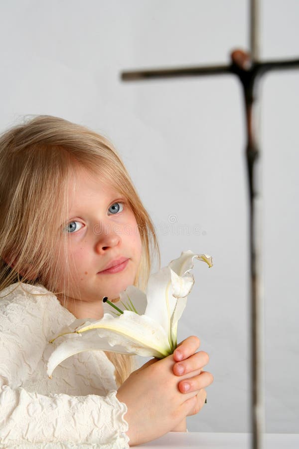 Little girl praying on the easter lilies background. Little girl praying on the easter lilies background