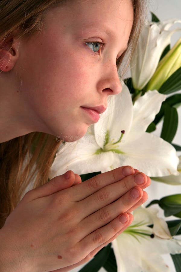 Little girl praying on the easter lilies background. Little girl praying on the easter lilies background