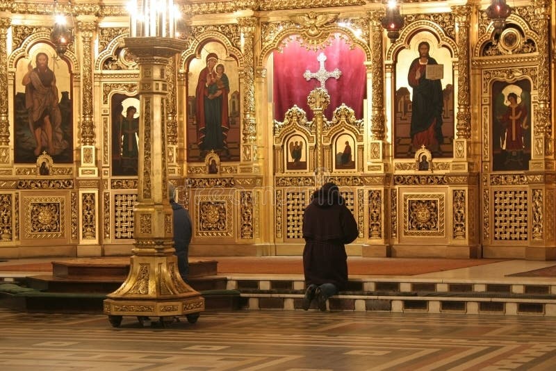 Una mujer en negro ora en cristiano iglesia.