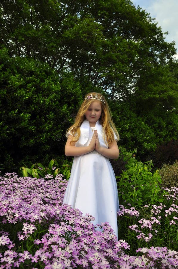 Beautiful little girl praying in a garden. Beautiful little girl praying in a garden