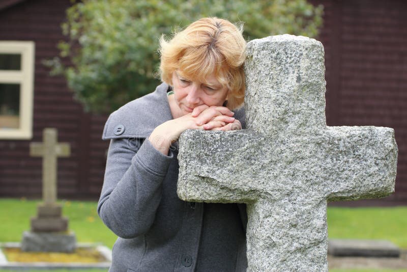 Praying at graveyard cross