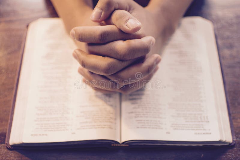 Praying hands on the Bible royalty free stock images Praying hands on the Bible royalty free stock images