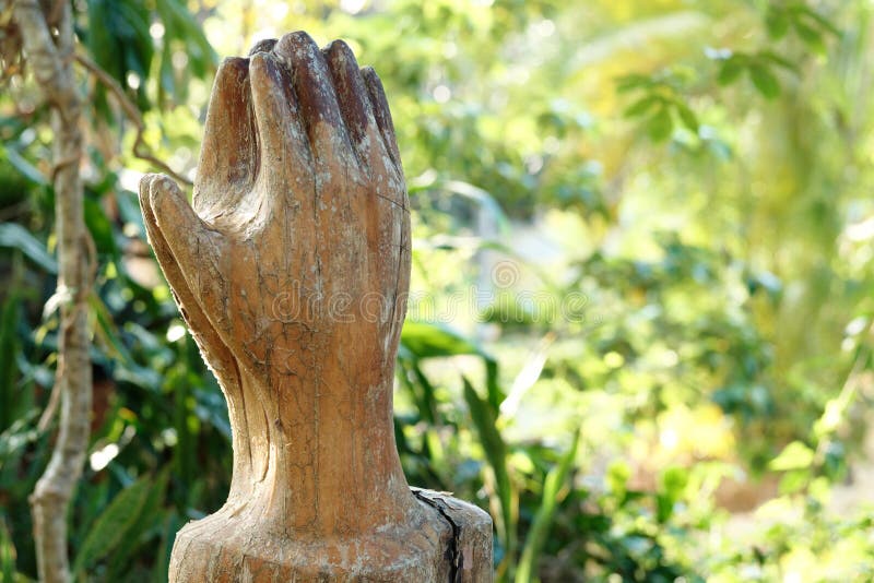 Praying Wooden Hands on green nature background. Religion spirituality belief and hope.
