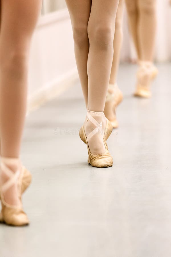 Pre-Pointe de studenten die van het tienerballet het staafwerk voor de posities van balletvoeten uitoefenen royalty-vrije stock foto Pre-Pointe de studenten die van het tienerballet het staafwerk voor de posities van balletvoeten uitoefenen royalty-vrije stock foto