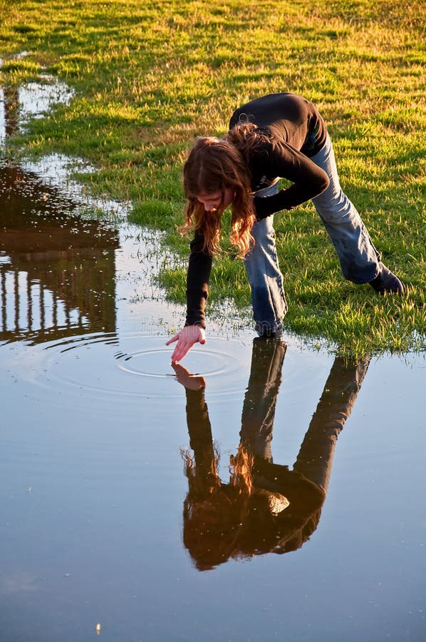 Pre-teem Girl Makes Ripple in Water with Hand