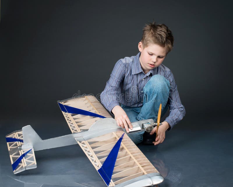 Pre-teen boy holding a wooden plane model. Kid playing with real stock photography Pre-teen boy holding a wooden plane model. Kid playing with real stock photography