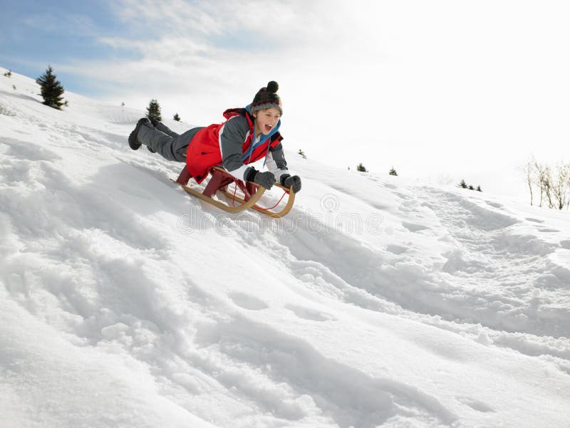 Pre-teen Boy On A Sled In The Snow stock photos Pre-teen Boy On A Sled In The Snow stock photos