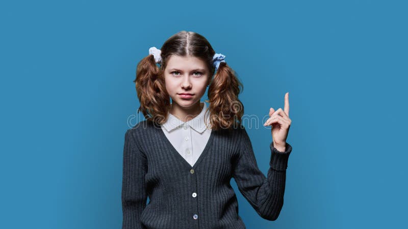 Preadolescente mostrando espacio de mano para fondo azul de texto fotografía de archivo