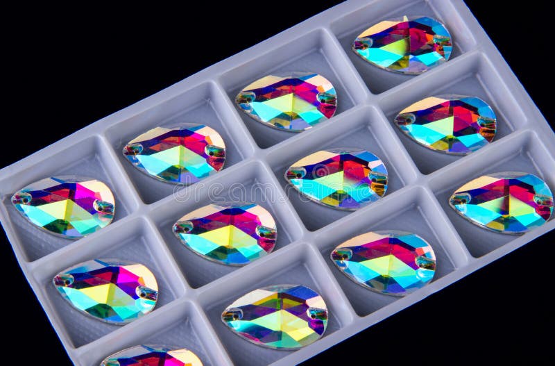 Precious stones crystals in the shape a tear drop in storage plate on a black background stock photography