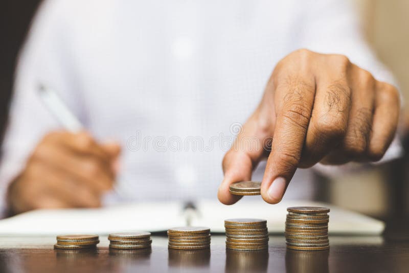 Precolocaci?n del concepto del dinero del ahorro por la mano masculina que pone negocio cada vez mayor de la pila de la moneda de foto de archivo libre de regalías Precolocaci?n del concepto del dinero del ahorro por la mano masculina que pone negocio cada vez mayor de la pila de la moneda de foto de archivo libre de regalías
