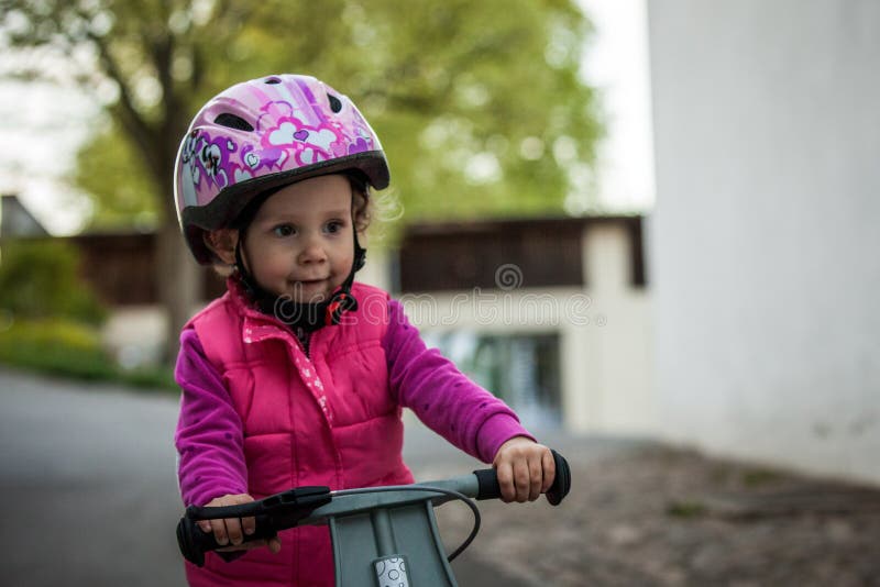 Preescolar que aprende equilibrar en la bicicleta en casco seguro fotos de archivo Preescolar que aprende equilibrar en la bicicleta en casco seguro fotos de archivo