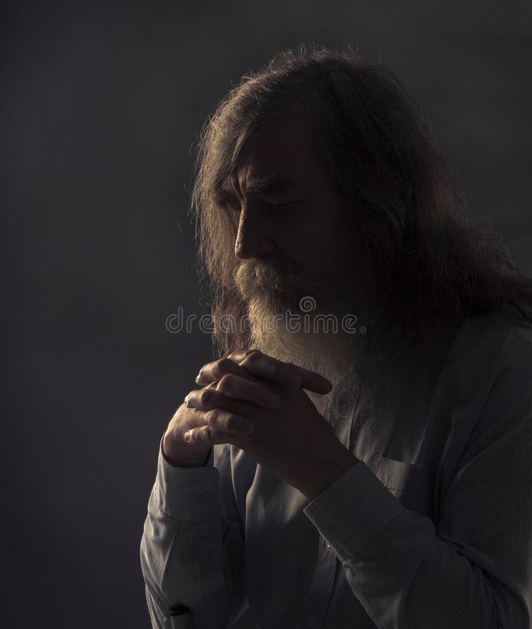 Preghiera senior, uomo anziano che prega con le mani piegate nello scuro fotografia stock libera da diritti Preghiera senior, uomo anziano che prega con le mani piegate nello scuro fotografia stock libera da diritti