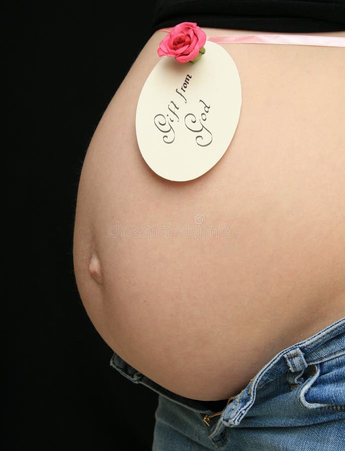 Pregnant woman with note around her belly: Gift from God. Pregnant woman with note around her belly: Gift from God