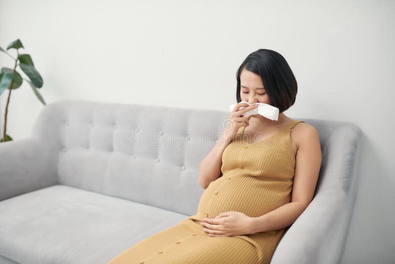 Pregnancy And Illness Sick Pregnant Woman Blowing Nose In Tissue