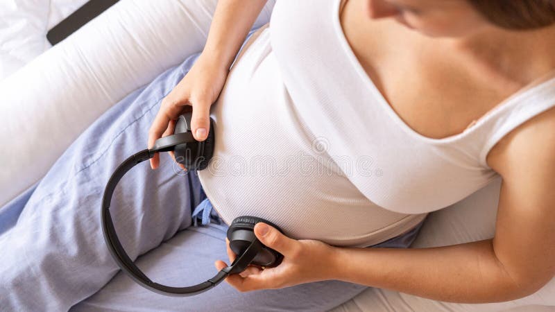 pregnant woman holding headphones on her belly. Music for baby. concept pregnancy  and music. Stock Photo