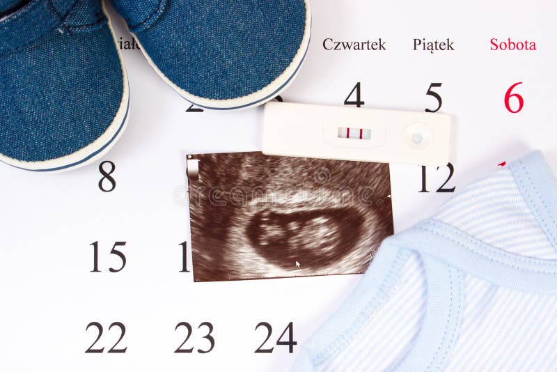 Pregnancy test, ultrasound scan of baby and clothing for newborn on calendar royalty free stock photos