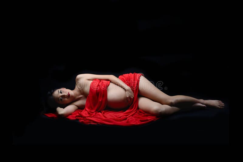 Pregnant asian woman laying down on red scarf