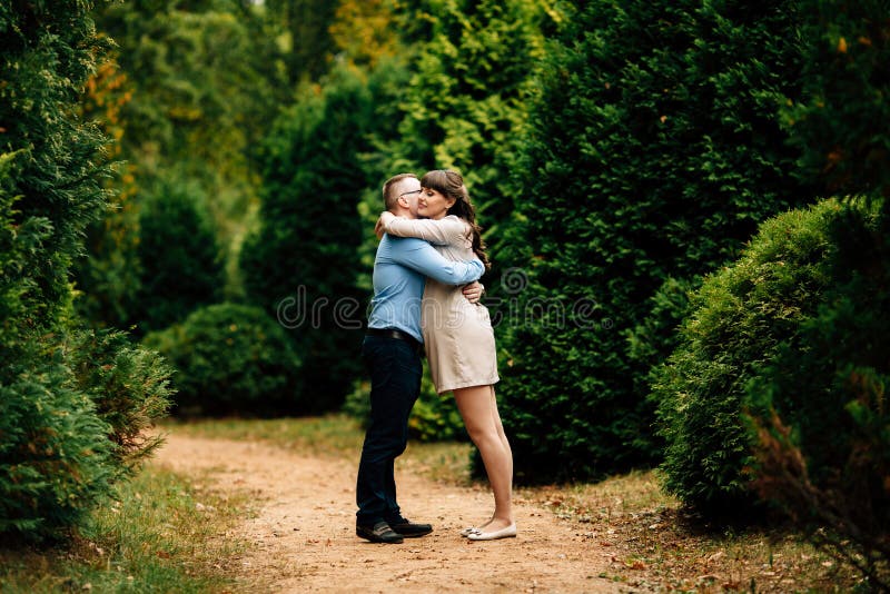 Pregnant Beautiful Woman And Her Handsome Husband Lovely Hugging In Autumn Park Stock Image 