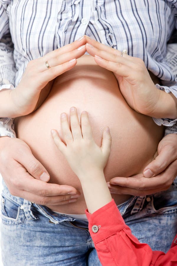 Pregnant belly with husband and child hands on it